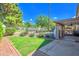 Back yard featuring well-maintained grass, mature trees and shrubbery plus the pool and patio at 715 N Cholla St, Chandler, AZ 85224