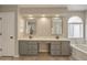 Bathroom with dual sinks, framed mirrors, soaking tub, and tiled floors at 715 N Cholla St, Chandler, AZ 85224