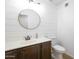 Chic bathroom featuring a round mirror, shiplap walls and dark wood vanity at 715 N Cholla St, Chandler, AZ 85224