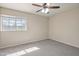 Cozy bedroom with a window for natural light, neutral color scheme, plush carpet, and a ceiling fan at 715 N Cholla St, Chandler, AZ 85224