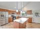 Bright kitchen with stainless steel appliances, spacious island, and wood cabinets at 715 N Cholla St, Chandler, AZ 85224