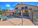 Backyard pool with rock waterfall feature, grassy lawn and covered patio at 715 N Cholla St, Chandler, AZ 85224