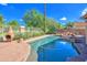 Sparkling pool with rock waterfall feature and mature landscaping creating a serene outdoor oasis at 715 N Cholla St, Chandler, AZ 85224