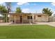 The back of the house has a covered patio, an artificial turf backyard, and stone pavers at 7250 E Mckellips Rd, Scottsdale, AZ 85257