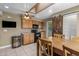 Spacious kitchen featuring wood cabinets, black appliances, a wine cooler, and a dining area at 7250 E Mckellips Rd, Scottsdale, AZ 85257