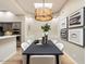 Bright dining room area illuminated by a modern chandelier, featuring stylish artwork and seamless access to the kitchen at 7955 E Chaparral Rd # 115, Scottsdale, AZ 85250