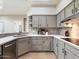 Well-equipped kitchen featuring gray cabinetry, modern appliances, and a functional layout with a stylish backsplash at 7955 E Chaparral Rd # 115, Scottsdale, AZ 85250
