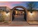 Inviting entrance to a Spanish-style home with a brick archway and charming desert landscaping at 8035 E Paraiso Dr, Scottsdale, AZ 85255