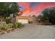 Home with spacious garage and beautiful landscaping features desert-style plants and natural rock ground cover at 8035 E Paraiso Dr, Scottsdale, AZ 85255