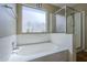 Bathroom featuring a large soaking tub with a window, as well as a glass enclosed shower at 823 W Bradford Dr, Gilbert, AZ 85233