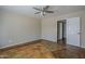 Bedroom with ceiling fan, unique concrete floors, and access to an adjoining bathroom at 823 W Bradford Dr, Gilbert, AZ 85233