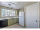Bright kitchen with a large window, olive green cabinets, a white refrigerator, and a black dishwasher at 823 W Bradford Dr, Gilbert, AZ 85233