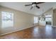 View of the living room with stained concrete flooring, windows, ceiling fan and pass through to kitchen at 823 W Bradford Dr, Gilbert, AZ 85233