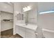 Neutral bathroom with a white vanity, single sink, carpeted walk-in closet and toilet at 9017 E June Cir, Mesa, AZ 85207