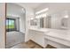 Bathroom vanity with dual sinks, large mirrors, and modern lighting fixtures at 9017 E June Cir, Mesa, AZ 85207