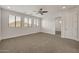 Bright bedroom features a ceiling fan, carpeted floor, and a view of desert landscape from windows at 9017 E June Cir, Mesa, AZ 85207
