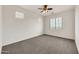 Bright bedroom features a ceiling fan, carpeted floor, and natural light from large windows at 9017 E June Cir, Mesa, AZ 85207