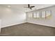 Bonus room featuring a ceiling fan, carpeted floor, and natural light from large windows at 9017 E June Cir, Mesa, AZ 85207
