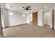 Carpeted main bedroom with ceiling fan and decorative barn door to the bathroom at 9017 E June Cir, Mesa, AZ 85207