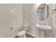 A well-lit powder room has a pedestal sink, toilet, and contemporary finishes at 9017 E June Cir, Mesa, AZ 85207
