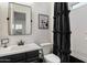 Bathroom featuring a black vanity, modern fixtures, toilet, and a shower with a decorative black shower curtain at 9445 W Monte Lindo --, Peoria, AZ 85383
