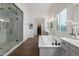 The main bathroom has a soaking tub, walk-in shower, double sinks, and wood-look floors at 9445 W Monte Lindo --, Peoria, AZ 85383
