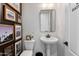 Stylish powder room with pedestal sink, unique wall decor, and contemporary fixtures at 9445 W Monte Lindo --, Peoria, AZ 85383