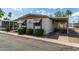 Cozy mobile home with awnings, carport, landscaping, and a paved driveway at 9501 E Broadway Rd # 168, Mesa, AZ 85208