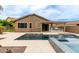 Backyard featuring a pool, outdoor kitchen, covered patio, and landscaping, perfect for entertaining at 10261 W Foothill Dr, Peoria, AZ 85383