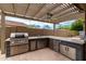 The outdoor kitchen has stainless steel appliances and countertop space for entertaining outdoors at 10261 W Foothill Dr, Peoria, AZ 85383