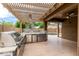 Gourmet outdoor kitchen with stainless steel grill and pergola covered patio at 10261 W Foothill Dr, Peoria, AZ 85383
