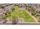 An aerial view of a well-maintained park with lush green grass, walking trails, and scattered trees within a residential neighborhood at 10261 W Foothill Dr, Peoria, AZ 85383