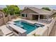 A stunning pool with a built-in hot tub, integrated fire feature, and a covered outdoor kitchen area at 10261 W Foothill Dr, Peoria, AZ 85383