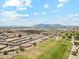 Aerial view of a community with single-story homes, a golf course, and a mountain backdrop at 11320 E Newcastle Ave, Mesa, AZ 85209