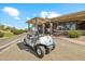 A Sunland Springs golf cart sits outside of the golf course building showcasing the surrounding landscaping at 11320 E Newcastle Ave, Mesa, AZ 85209