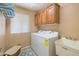 Functional laundry room featuring modern appliances, ample cabinet space, and a utility sink at 11320 E Newcastle Ave, Mesa, AZ 85209
