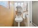 Cozy powder room featuring a pedestal sink, oval mirror, and natural lighting from a window at 11320 E Newcastle Ave, Mesa, AZ 85209