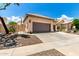 Charming home featuring a two-car garage, beautiful landscaping and a bright blue sky at 14058 S 24Th Way, Phoenix, AZ 85048