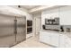 Kitchen featuring stainless steel refrigerator, ovens, and cooktop, paired with bright, white cabinetry at 14058 S 24Th Way, Phoenix, AZ 85048