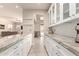 Modern kitchen with white cabinets, marble countertops, and views into the living area at 14058 S 24Th Way, Phoenix, AZ 85048
