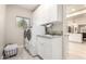 Well-equipped laundry room with a sink, modern washer and dryer, white cabinets, and tile floors at 14058 S 24Th Way, Phoenix, AZ 85048