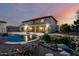Landscaped backyard with pool, pond, and fire pit, creating a serene outdoor oasis at 14494 W Yucatan St, Surprise, AZ 85379