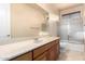 Bright bathroom features a large mirror, cherry cabinets, and a shower with glass door at 14494 W Yucatan St, Surprise, AZ 85379