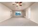 Bright bedroom featuring neutral carpet, ceiling fan, and ample natural light through large windows at 14494 W Yucatan St, Surprise, AZ 85379