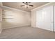 Bedroom with neutral walls and carpet, ceiling fan, closet, and shelves at 14494 W Yucatan St, Surprise, AZ 85379