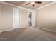 Bedroom with neutral walls and carpet, ceiling fan, and an open doorway at 14494 W Yucatan St, Surprise, AZ 85379