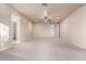 Large bedroom with neutral carpet and walls, a ceiling fan, and access to the closet and bathroom at 14494 W Yucatan St, Surprise, AZ 85379