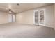 Expansive bedroom featuring carpeted floors, a ceiling fan, and French doors to the backyard at 14494 W Yucatan St, Surprise, AZ 85379