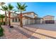 A tan two-story home with a three-car garage, desert landscaping, and several tall palm trees at 14494 W Yucatan St, Surprise, AZ 85379