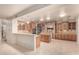 Spacious eat-in kitchen features granite counters, island, tile flooring, breakfast bar, and stone accent wall at 14494 W Yucatan St, Surprise, AZ 85379
